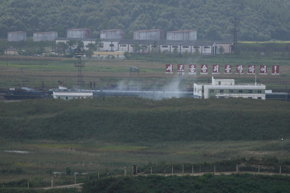 A green train with yellow trimmings, resembling one used by North Korean leader Kim Jong Un on his previous travels, is seen steaming by a slogan which reads "Towards a new victory" on the North Korea border with Russia and China seen from China's Yiyanwang Three Kingdoms viewing platform in Fangchuan in northeastern China's Jilin province on Monday, Sept. 11, 2023. Russia and North Korea confirmed Monday that North Korean leader Kim Jong Un will visit Russia in a highly anticipated meeting with President Vladimir Putin that has sparked Western concerns about a potential arms deal for Moscow's war in Ukraine. (AP Photo/Ng Han Guan)