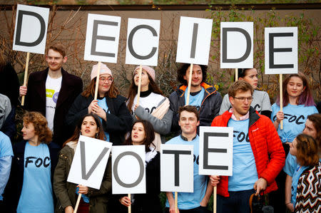 A group of young people hold up placards during a demonstration to demand a second referendum on Brexit outside the Houses of Parliament in London, Britain, December 12, 2018. REUTERS/Phil Noble