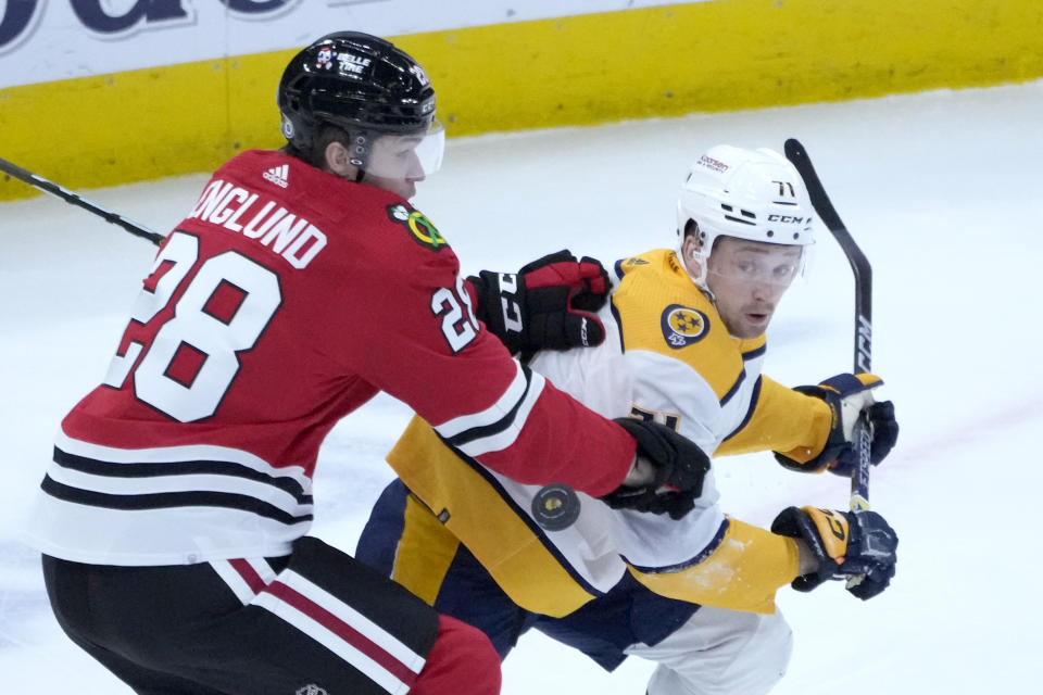 Chicago Blackhawks' Andreas Englund, left, keeps Nashville Predators' Rasmus Asplund away from the puck during the second period of an NHL hockey game Saturday, March 4, 2023, in Chicago. (AP Photo/Charles Rex Arbogast)