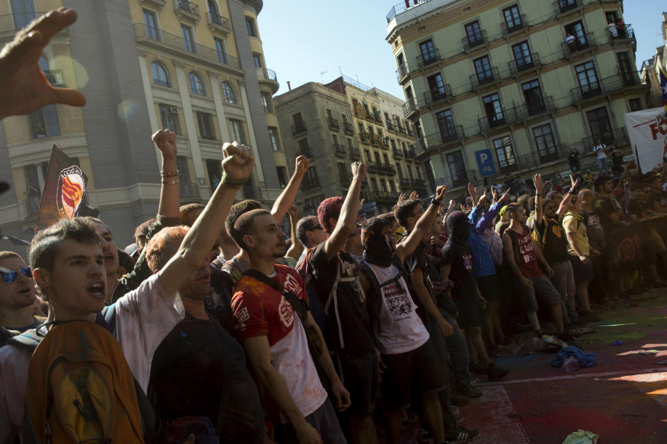 Pro independence demonstrators react as they are stop by Catalan police officers on their way to meet demonstrations by member and supporters of National Police and Guardia Civil, as coloured powder is seen in the air after being thrown by protesters, in Barcelona on Saturday, Sept. 29, 2018. (AP Photo/Emilio Morenatti)