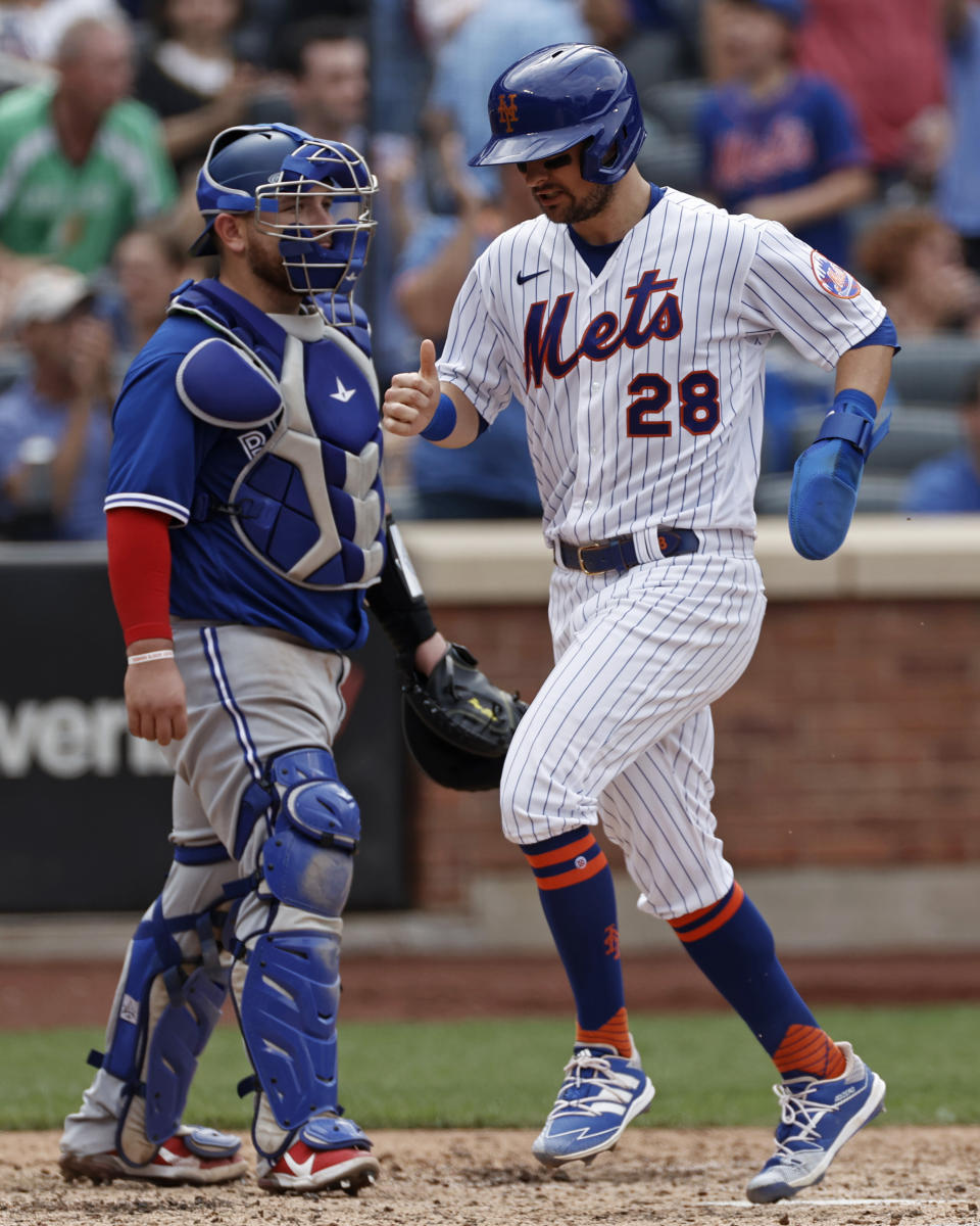 New York Mets' J.D. Davis (28) scores a run in front of Toronto Blue Jays catcher Alejandro Kirk in the sixth inning during a baseball game Sunday, July 25, 2021, in New York. (AP Photo/Adam Hunger)