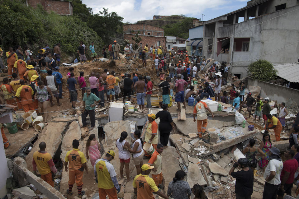 Residents, volunteers and firefighters work over the debris after a mudslide in Boa Esperanca or "Good Hope" shantytown in Niteroi, Brazil, Saturday, Nov. 10, 2018. Several people were killed and others injured in a mudslide near Rio de Janeiro on Saturday, Brazilian authorities said. (AP Photo/Leo Correa)