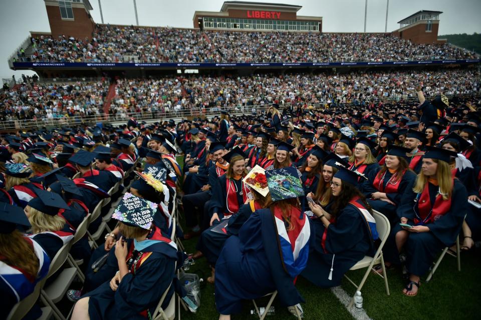 Graduates chat as students continue to walk in for Liberty University's Commencement ceremony in Lynchburg, Saturday, May 11, 2019. More than 45,000 people attended the event where Vice President Mike Pence delivered the commencement speech.