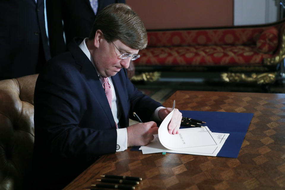 Mississippi Gov. Tate Reeves signs the bill retiring the last state flag in the United States with the Confederate battle emblem, during a ceremony at the Governor's Mansion in Jackson, Miss., Tuesday, June 30, 2020. Upon the bill's signing, the flag lost its official status. (AP Photo/Rogelio V. Solis, Pool)