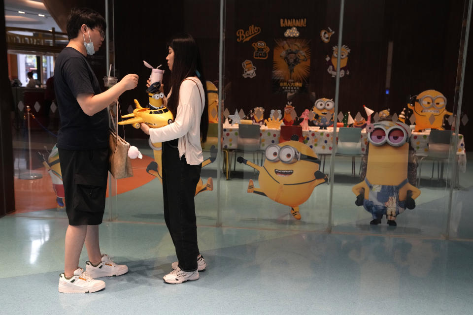 Visitors to a cinema showing the latest Minions: The Rise of Gru movie pass by an event room with the Minions theme in Beijing, Wednesday, Aug. 24, 2022. Chinese viewers of the latest hit Minions movie are getting an added postscript that reinforces a message: Crime doesn't pay. Foreign films have long been targeted for references to subjects sensitive to the ruling Communist Party, such as Taiwan, the Dalai Lama and human rights. (AP Photo/Ng Han Guan)
