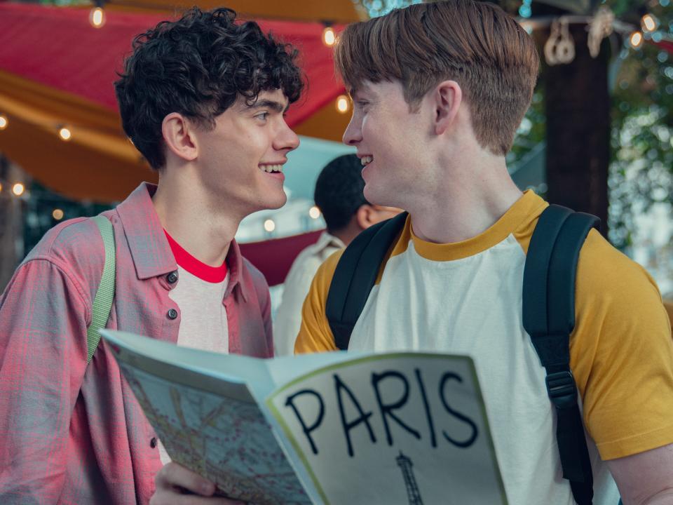 charlie and nick in heartstopper, looking lovingly into each others' eyes and hodling a map to paris