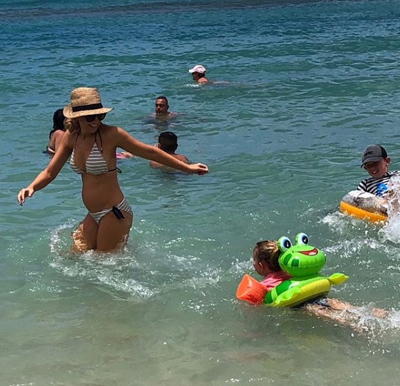 Carrie showed off her bump in striped bikinis while playing with her two kids. Photo: Instagram/bickmorecarrie