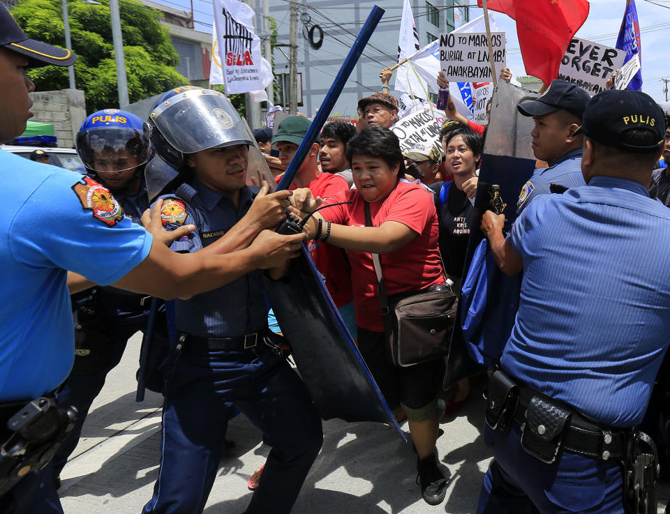 Filipino anti riot police try to block protestors during a protest