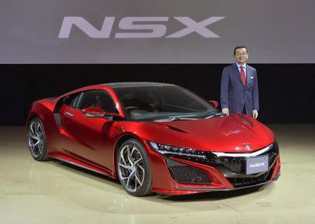 Honda CEO Takahiro Hachigo poses in front of the new Honda NSX, at its Japan launch event in Tokyo, Japan, in this photo taken by Kyodo August 25, 2016. Mandatory credit Kyodo/via REUTERS