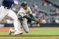 Oakland Athletics starting pitcher Luis Medina scrambles to throw out Seattle Mariners' Jarred Kelenic at first base during the fourth inning of a baseball game Tuesday, May 23, 2023, in Seattle. (AP Photo/Caean Couto)