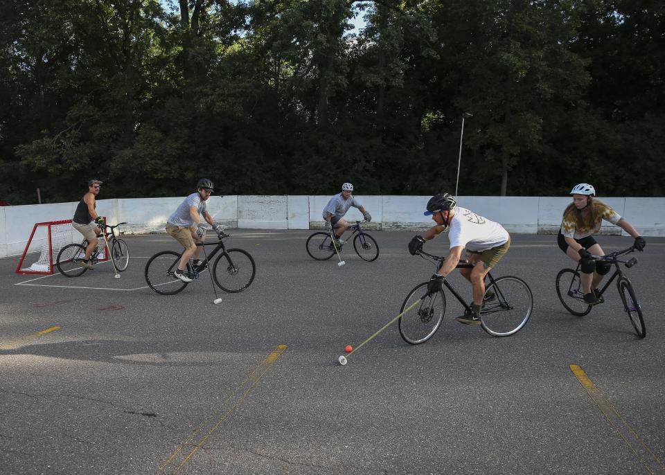 Tim Torkelson controls the ball as he rides near the goal during a game of bicycle polo on Thursday, August 11, 2022, at Riverside Park in Wausau, Wis.