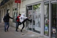 Youths break a bank window during a demonstration to protest the the government's proposed labor law reforms in Nantes, France, May 26, 2016. REUTERS/Stephane Mahe