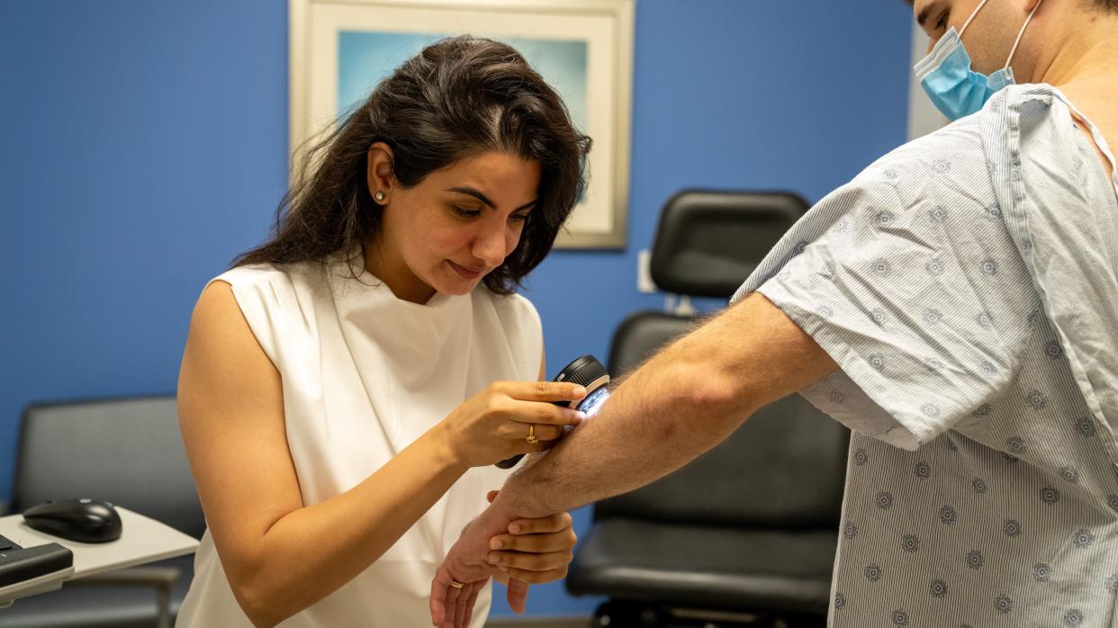 Dr. Sanjana Iyengar, a Lakeland Regional Health dermatologist, examines the skin of Lance Devore during a skin cancer screening at LRH Hollis Cancer Center.