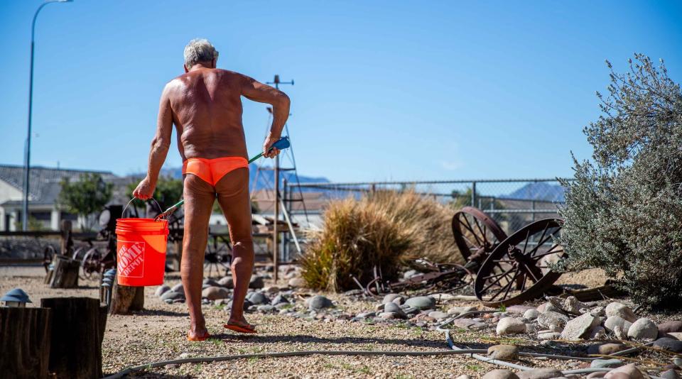 Phil Hertel maintains his yard outside his home wearing a speedo and matching flip flops, as he's done for decades, in Laveen on Jan. 30, 2024.