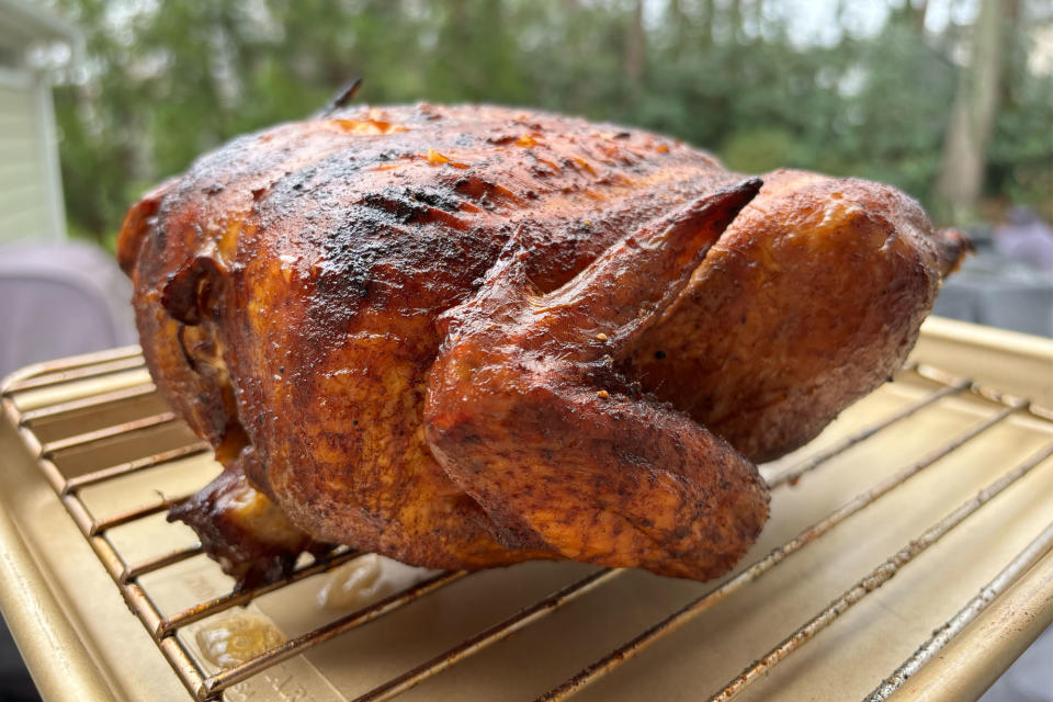 <p>A whole smoked chicken sitting on a baking sheet after being smoked inside the GE Profile Smart Indoor Smoker.</p>
