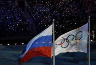 The Russian national flag flutters next to the Olympics flag during the closing ceremony for the 2014 Sochi Winter Olympics, February 23, 2014. REUTERS/Issei Kato