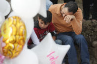 Family members mourn next to the grave of 7-year-old murder victim Fatima in Mexico City, Tuesday, Feb. 18, 2020. Fatima's body was found wrapped in a bag and abandoned in a rural area on Saturday. Five people have been questioned in the case, and video footage of her abduction exists. (AP Photo/Marco Ugarte)