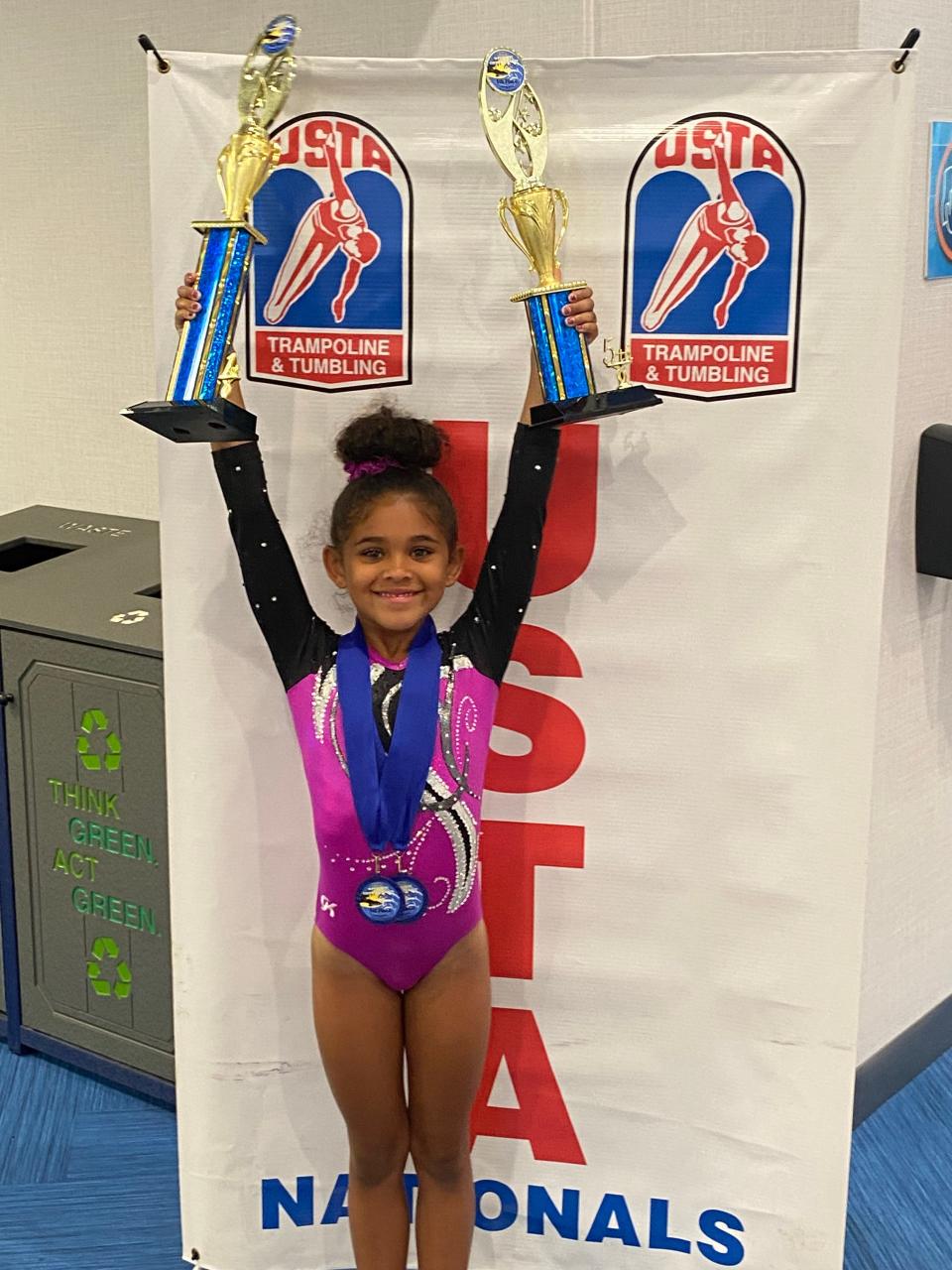 Byron 6-year-old Kylia Edmonson holds up her trophies after winning two national titles at the United States Tumbling and Trampoline Association championships in Lakeland, Florida. PHOTO PROVIDED BY KYWAN EDMONSON