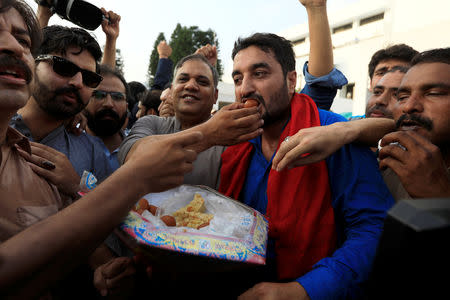 Supporters of Imran Khan, chairman of Pakistan Tehreek-e-Insaf (PTI) party celebrate after Khan was elected as Prime Minister, outside the parliament house in Islamabad, Pakistan August 17, 2018. REUTERS/Faisal Mahmood