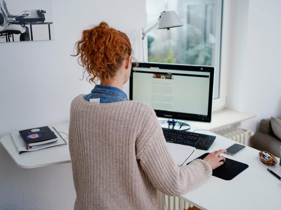 a woman works at her desk in her home