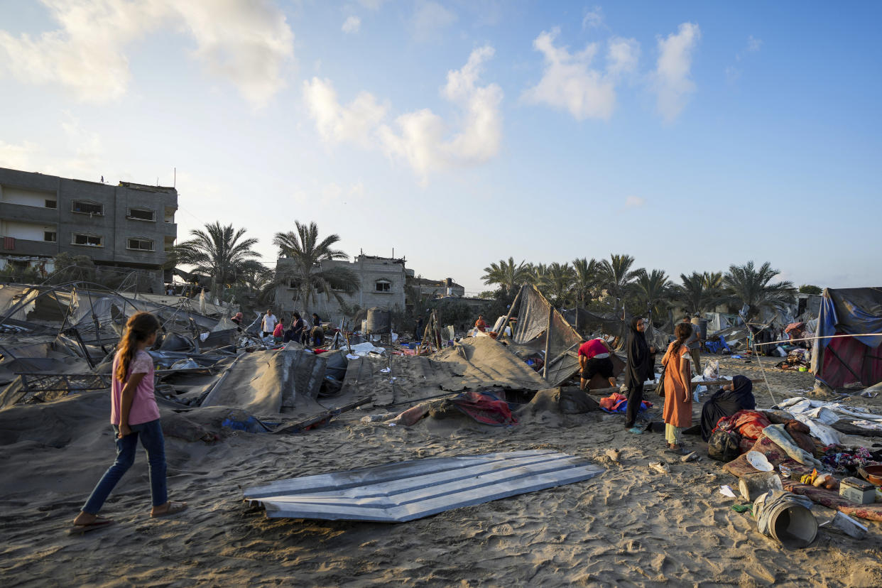 Palestinians look at the destruction after an Israeli airstrike on a crowded tent camp housing Palestinians displaced by the war in Muwasi, Gaza Strip, Tuesday, Sept. 10, 2024. An Israeli strike killed at least 40 people and wounded 60 others early Tuesday, Palestinian officials said. Israel said it targeted "significant" Hamas militants, allegations denied by the militant group. (AP Photo/Abdel Kareem Hana)