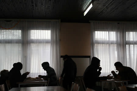Men have lunch at the camp for refugees and migrants in the Belgrade suburb of Krnjaca, Serbia January 16, 2018. Picture taken January 16, 2018 REUTERS/Djordje Kojadinovic