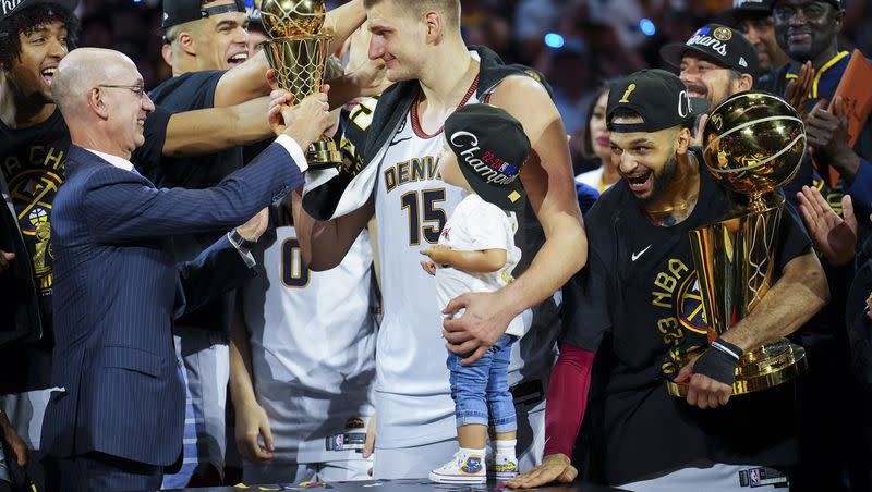Commissioner Adam Silver, left, hands the Finals MVP award to Denver Nuggets center Nikola Jokic, center, after the team won the NBA Championship with a victory over the Miami Heat in Game 5 of basketball’s NBA Finals, Monday, June 12, 2023, in Denver.