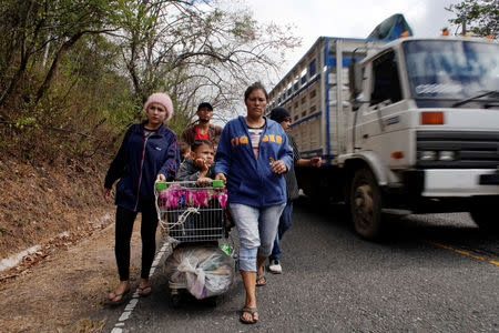 Migrants from Honduras use a supermarket cart to carry children as they walk towards the United States in Padre Miguel, Guatemala, January 16, 2019 REUTERS/Alexandre Meneghini