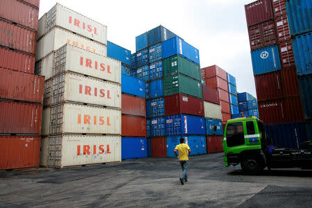 FILE PHOTO: A truck driver walks past a stack of IRISL containers at a depot in northern Singapore February 4, 2012. REUTERS/Thomas White/File Photo