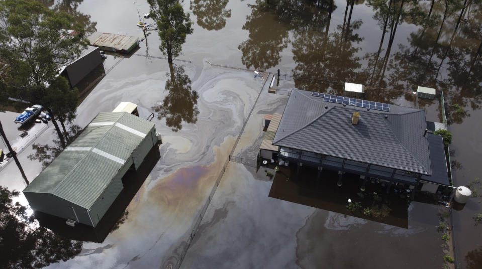 In this drone photo a property is surrounded by flood waters in Londonderry on the outskirts of Sydney, Australia, Tuesday, March 23, 2021. Hundreds of people have been rescued from floodwaters that have isolated dozens of towns in Australia's most populous state of New South Wales and forced thousands to evacuate their homes as record rain continues to inundate the countries east coast. (AP Photo/Mark Baker)