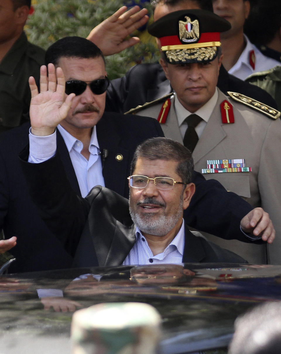 Egyptian President Mohammed Morsi, center, waves to worshippers ash he arrives for Friday prayers at Sayyeda Zainab mosque in Cairo, Egypt, Friday, Sept. 7, 2012. (AP Photo/Ahmed Ali)