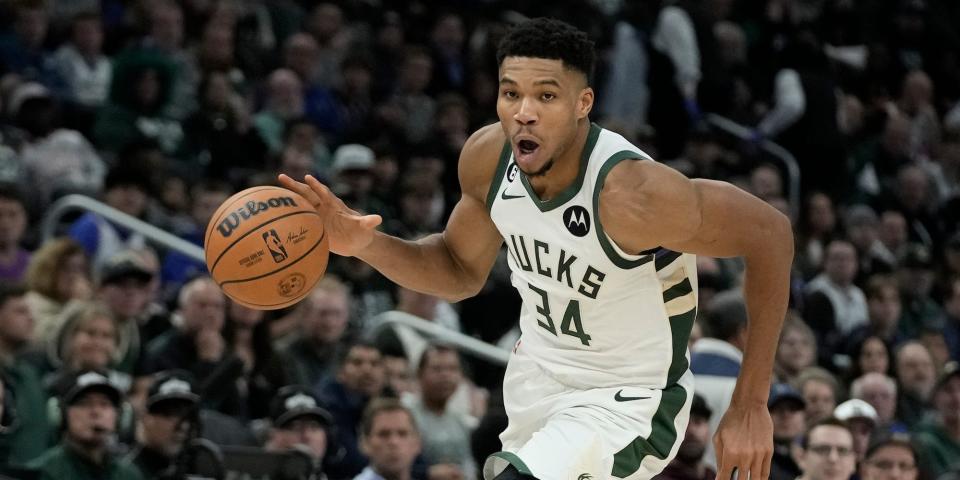 Giannis Antetokounmpo dribbles the ball and drives the lane during a Bucks game.