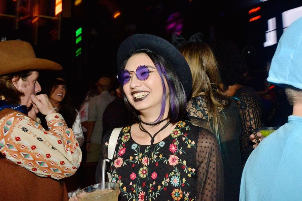 A Coachella-themed Halloween costume featuring purple sunglasses and a floral shirt