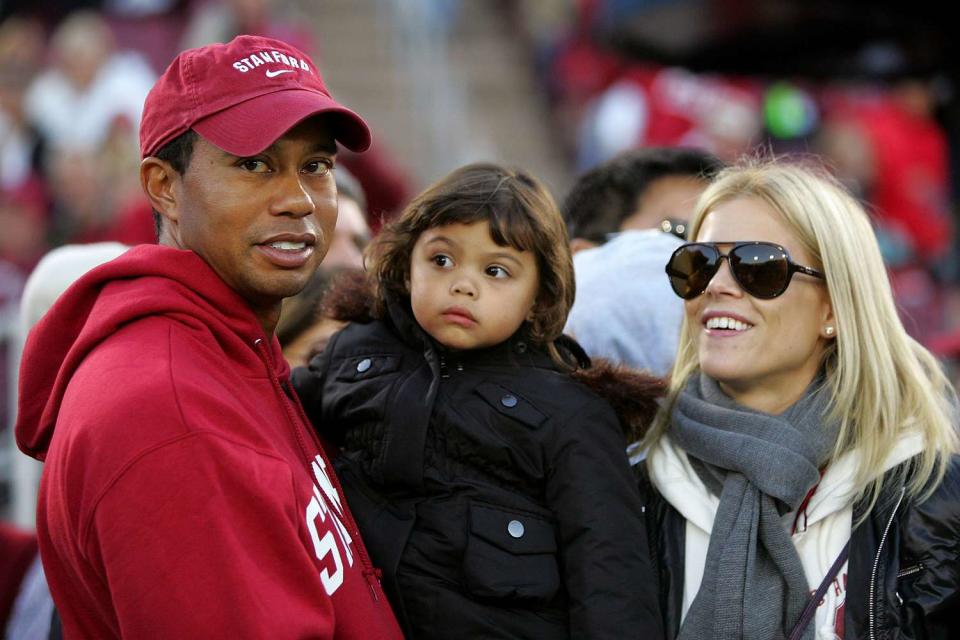 Tiger Woods holds his daugher, Sam, and stands next to his wife, Elin Nordegren, on the sidelines before the Cardinal game against the California Bears at Stanford Stadium on November 21, 2009 in Palo Alto, California