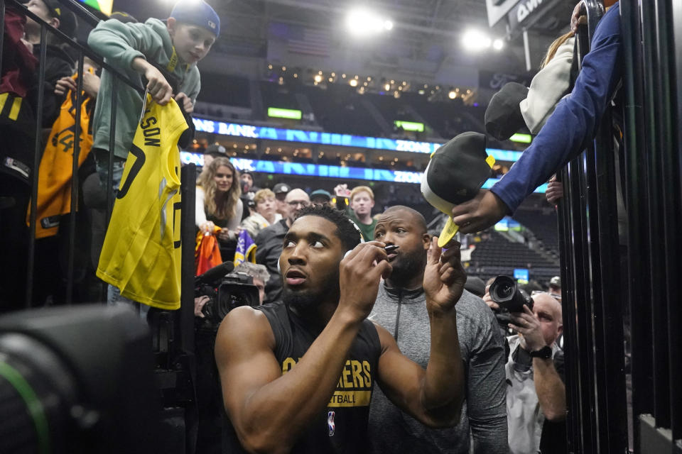 Cleveland Cavaliers guard Donovan Mitchell signs autographs before the team's NBA basketball game against the Utah Jazz on Tuesday, Jan. 10, 2023, in Salt Lake City. (AP Photo/Rick Bowmer)