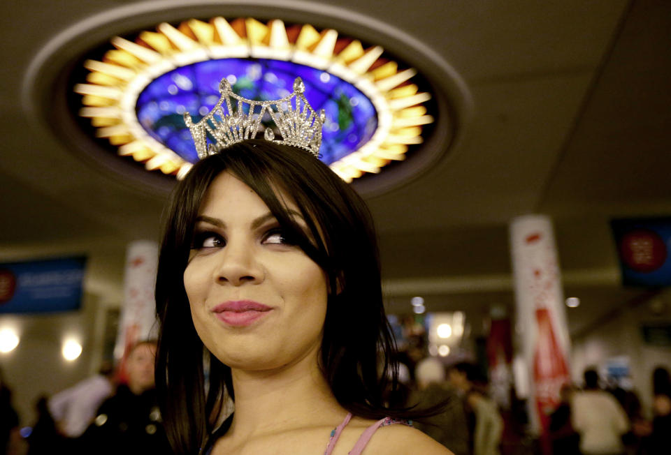 Miss Puerto Rico Collegiate Shaina Millan waits in the lobby of Boardwalk Hall before the Miss America 2014 pageant, Sunday, Sept. 15, 2013, in Atlantic City, N.J. (AP Photo/Julio Cortez)