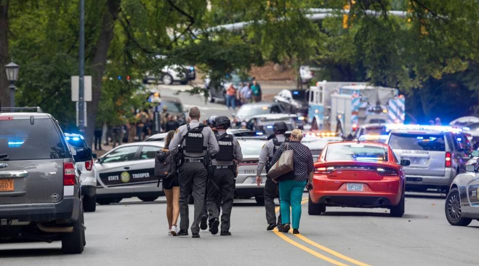 Heavily armed North Carolina State Troopers walk down South Road toward the Bell Tower on the University of North Carolina campus after a report of an armed and dangerous person on Monday, August 28. 2023 in Chapel Hill, N.C.