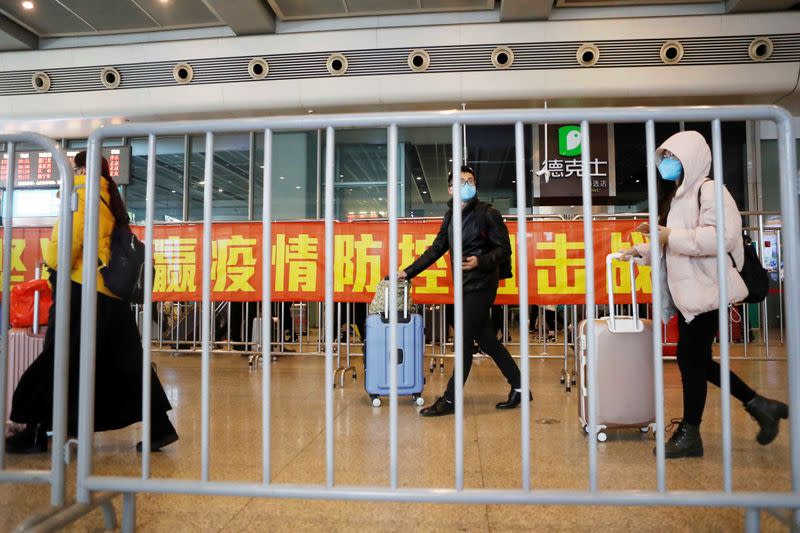 Passengers wearing face masks arrive at Shanghai Hongqiao Railway Station, as the country is hit by an outbreak of the novel coronavirus, in Shanghai