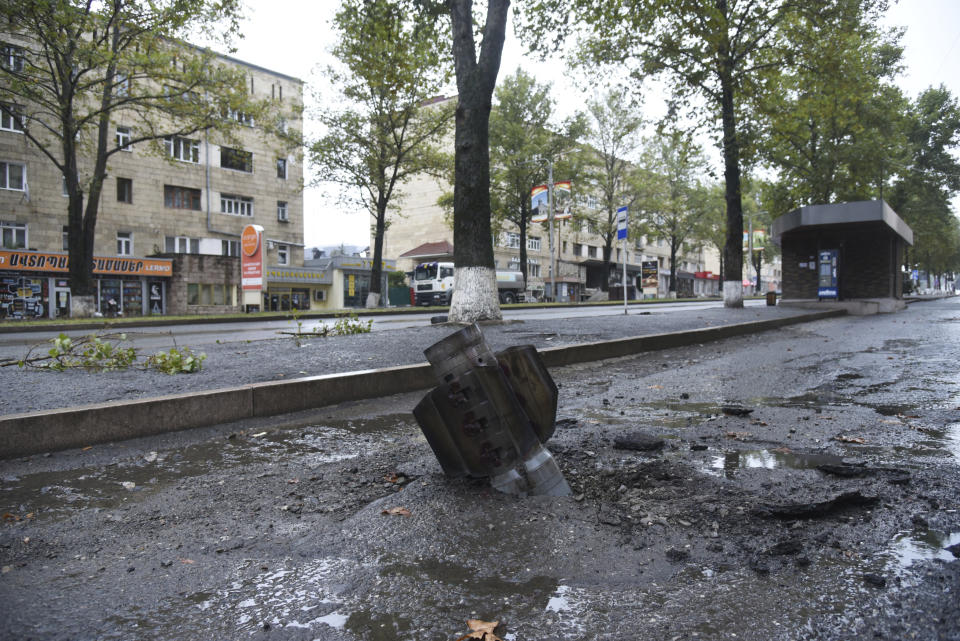 An unexploded projectile of a multiple rocket launcher stuck in a street after shelling by Azerbaijan's artillery during a military conflict in Stepanakert, self-proclaimed Republic of Nagorno-Karabakh, Azerbaijan, Monday, Oct. 5, 2020. Armenia accused Azerbaijan of firing missiles into the capital of the separatist territory of Nagorno-Karabakh, while Azerbaijan said several of its towns and its second-largest city were attacked. (David Ghahramanyan/NKR InfoCenter PAN Photo via AP)