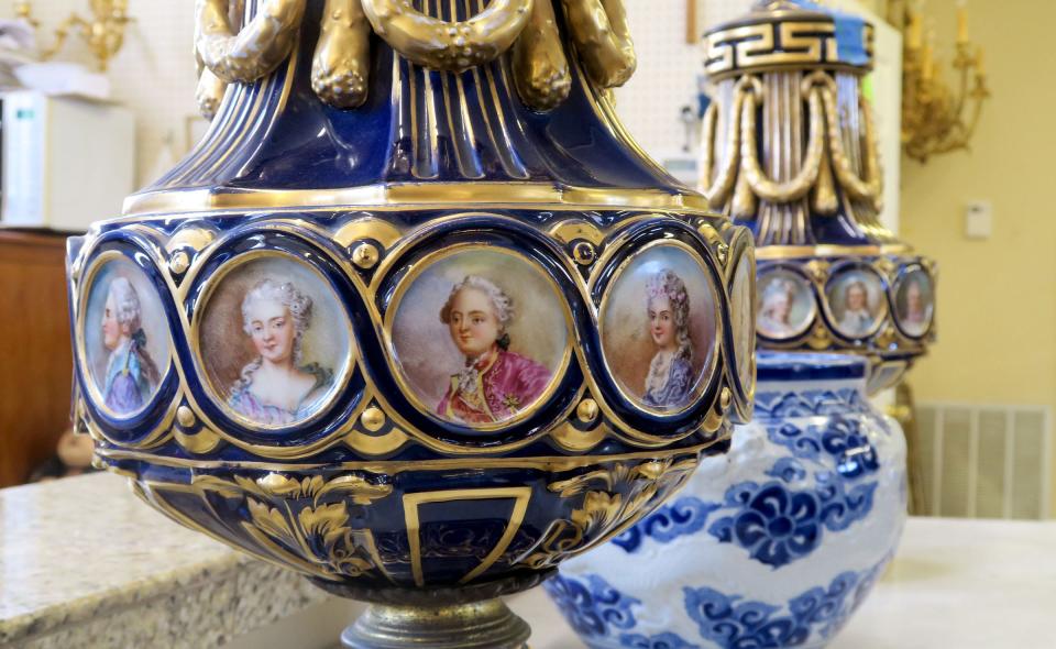 Images surround an antique vase in the first floor gallery at Mill House Antiques in Long Branch Monday, February 27, 2023.  The second-generation, Long Branch-based provider of antique furnishings, lighting, jewelry, grand pianos, and rare small valuables has been in operation since 1973.