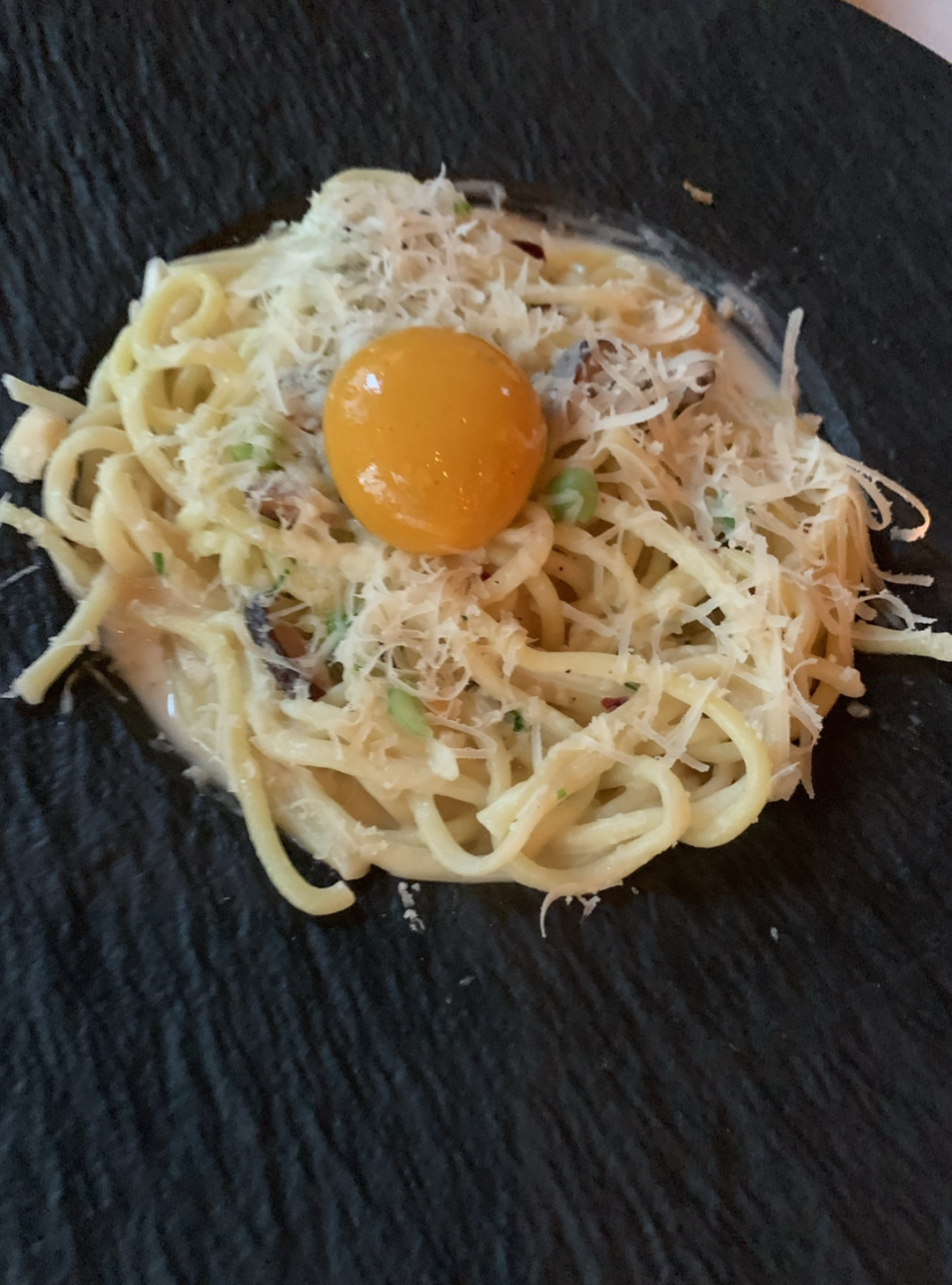 No, that's not a real egg: It's the pasta carbonara from plant-based restaurant Crossroads Kitchen, and it's made of a tomato. 