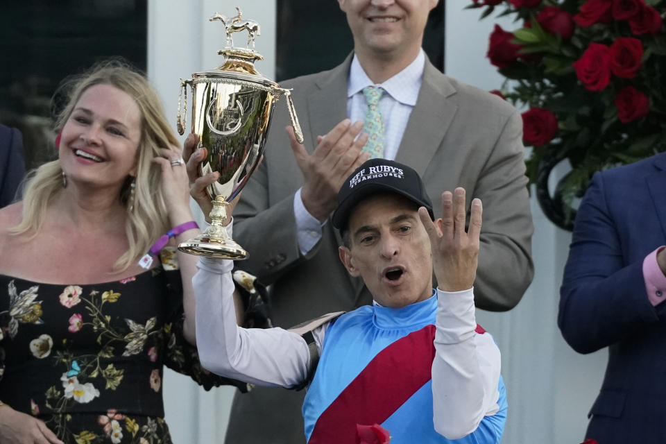 Jockey Velazquez holds the winner's trophy and four fingers indicating his fourth Kentucky Derby victory after winning the 147th running of the Kentucky Derby onboard Medina Spirit at Churchill Downs, Saturday, May 1, 2021, in Louisville, Ky. (AP Photo/Jeff Roberson)