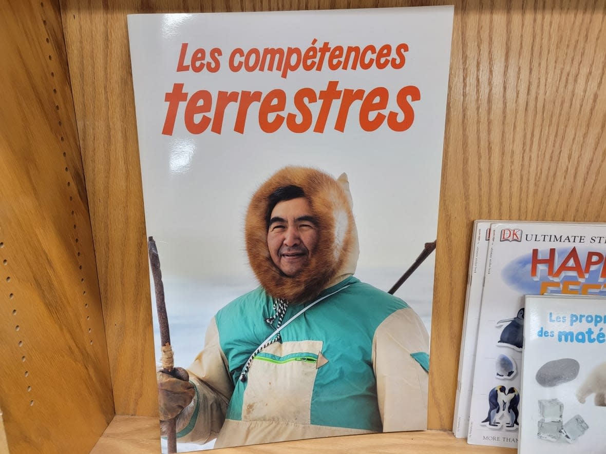 Les compétences terrestres, or Land Skills, comes in French, English and Inuktitut. It bears the image of Teman Avingaq on its cover — a photo taken of him during a narwhal hunt, but sold without his consent. The book is shown here at Arctic Ventures, a store in Iqaluit. (Meagan Deuling/CBC News - image credit)