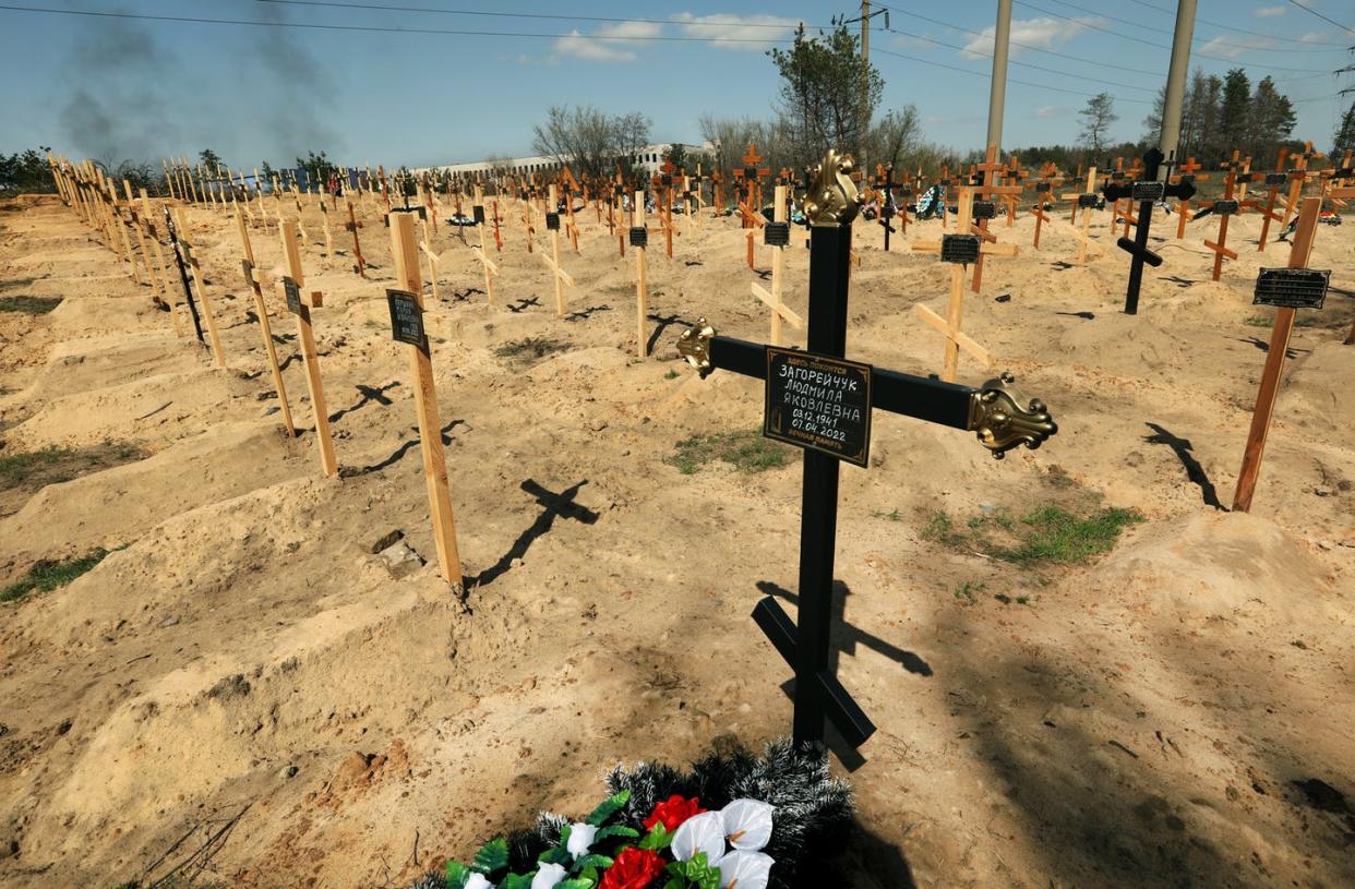 <span class="caption">Smoke rises on April 15, 2022, above 400 new graves in the town of Severodonetsk, Ukraine. </span> <span class="attribution"><a class="link " href="https://www.gettyimages.com/detail/news-photo/bulldozer-excaves-new-graves-in-yalovshchina-cemetery-for-news-photo/1240267875?adppopup=true" rel="nofollow noopener" target="_blank" data-ylk="slk:Carolyn Cole/Los Angeles Times via Getty Images;elm:context_link;itc:0;sec:content-canvas">Carolyn Cole/Los Angeles Times via Getty Images</a></span>