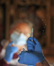 Health workers prepare the Pfizer-BioNTech vaccine inside Salisbury Cathedral in Salisbury, England, Wednesday, Jan. 20, 2021. Salisbury Cathedral opened its doors for the second time as a venue for the Sarum South Primary Care Network COVID-19 Local Vaccination Service. (AP Photo/Frank Augstein)