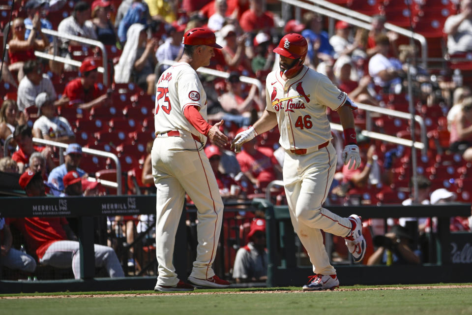 St. Louis Cardinals' Paul Goldschmidt (46) is congratulated by third base coach Ron 'Pop' Warner, left, after hitting a solo home run in the sixth inning of a baseball game against the Cincinnati Reds, Saturday, June 29, 2024, in St. Louis. (AP Photo/Joe Puetz)