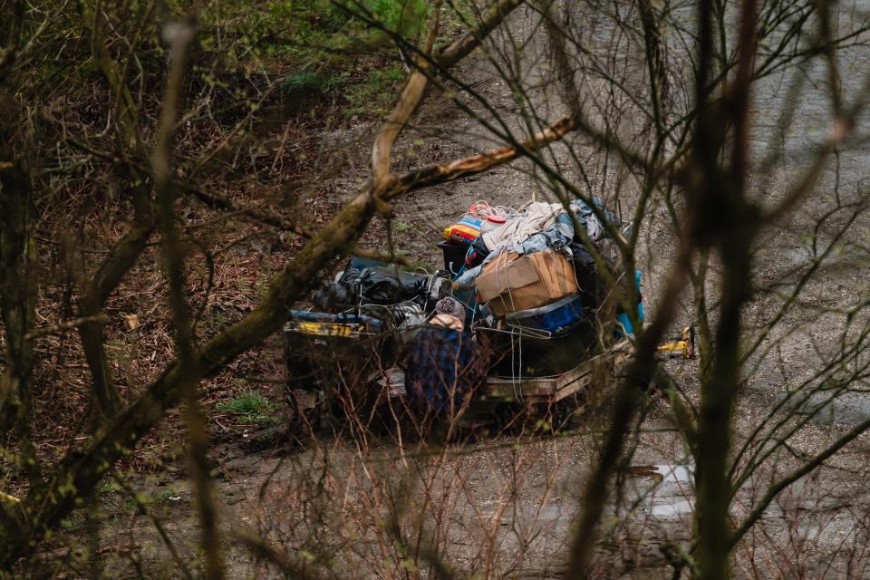 Two people experiencing homelessness, Tonya and Troy, are seen just beyond private property that was being used as a homeless encampment, Friday, April 5 in New Philadelphia. The land is private property and prior notice to evict was given months before. Tonya all the while has maintained that the property is hers.