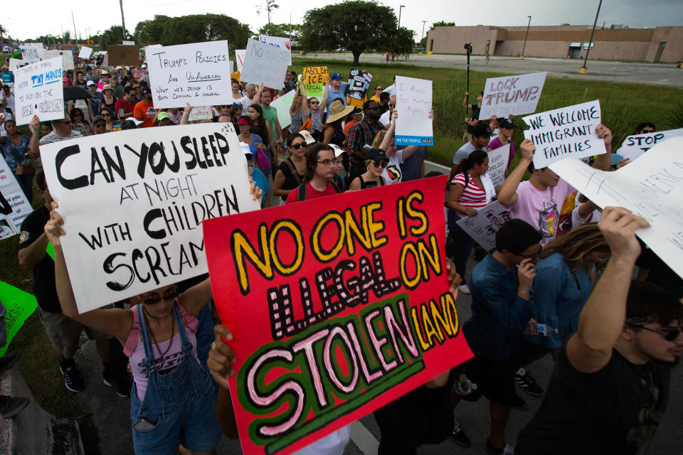 <p>Demonstrators gather and hold signs during the “Keep Families Together” rally outside of the Homestead temporary shelter for unaccompanied migrant children in Homestead, Fla., on Saturday, June 23, 2018. (Photo: Saul Martinez/Bloomberg via Getty Images) </p>