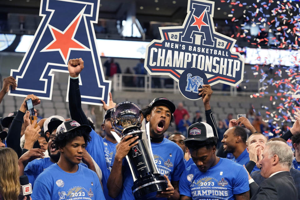 Memphis forward DeAndre Williams, center, holds the winner's trophy with Kendric Davis, left, Alex Lomax, right, and other teammates after winning the finals against Houston in the American Athletic Conference Tournament, Sunday, March 12, 2023, in Fort Worth, Texas. (AP Photo/LM Otero)