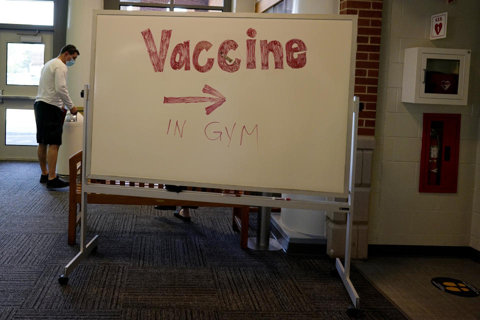 A sign points the way to administrate a dose of the Pfizer COVID-19 vaccine at London Middle School in Wheeling, Ill., Friday, June 11, 2021. After nearly 15 months of shutdowns, limited capacity and sheltering at home, the State of Illinois, including Chicago, fully reopened today. Businesses still can have their own rules for capacity, masks and social distancing. Masks are still required on public transportation and in airports, schools and hospitals. (AP Photo/Nam Y. Huh)